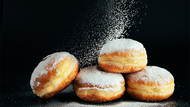 Powdered sugar poured onto donuts