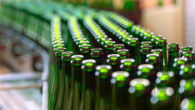 Green bottles on conveyor belt in factory